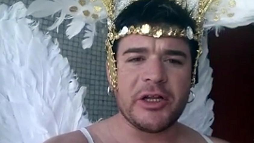 Junior Playboy pitutea dando el horóscopo a torso desnudo y usando alitas de ángel